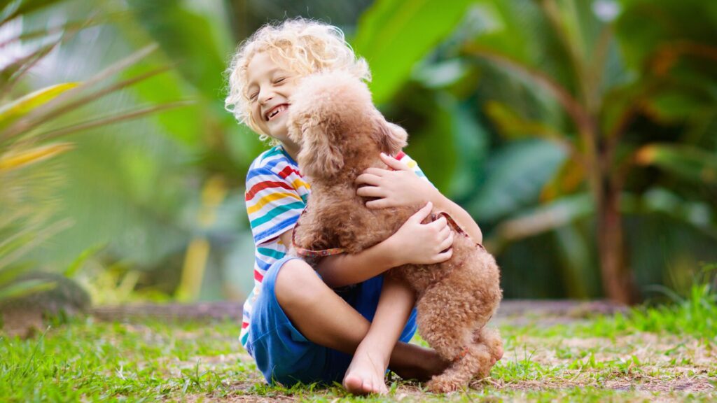 Criança sorrindo com cachorro no colo
