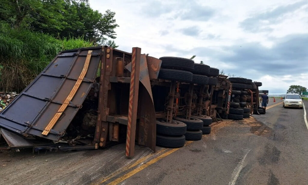 Motorista teve ferimentos leves e trânsito foi parcialmente bloqueado. A carreta com placas do Paraguai estava carregada com sucatas