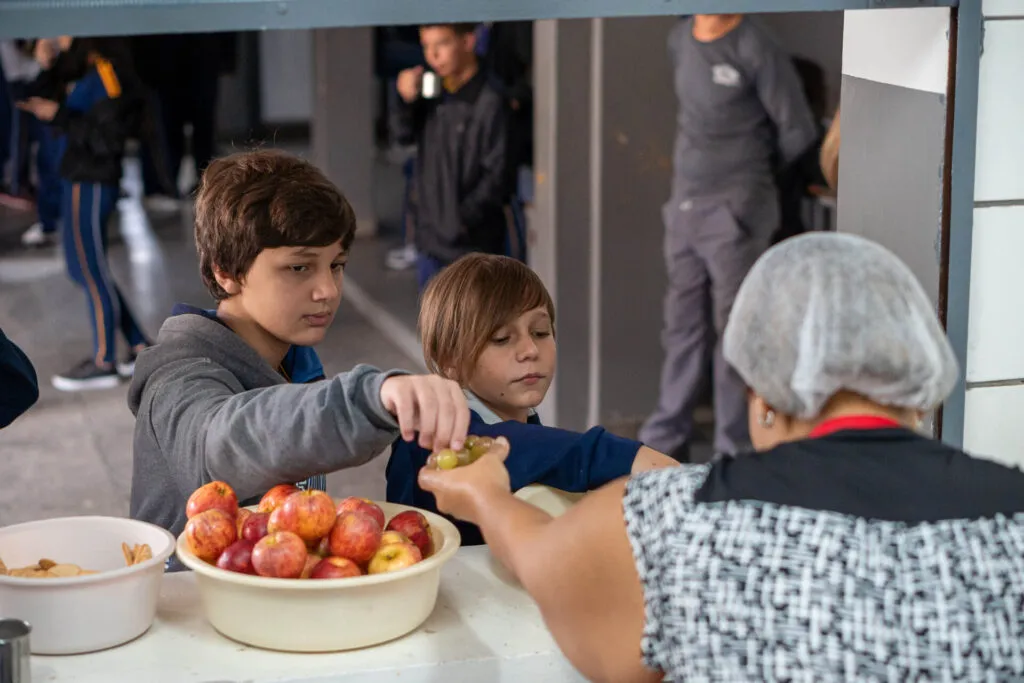 Alunos recebendo merenda da escola